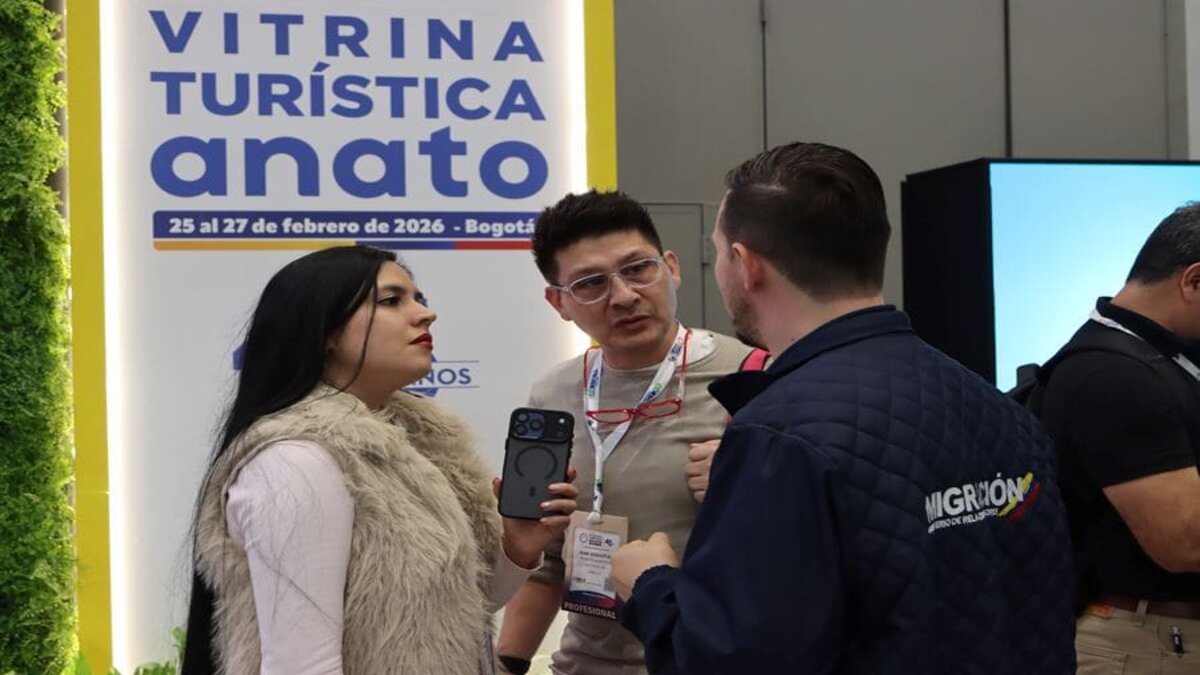 Oficial de migración con dos usuarios en la feria de ANATO